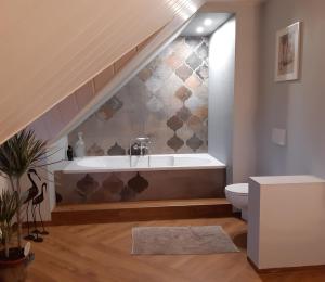 a bathroom with a bath tub and a toilet at Logis Am Park in Dessau +156 photos