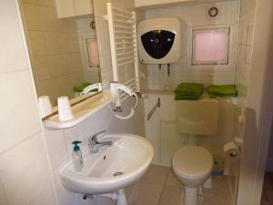 Baño blanco con lavabo y aseo en Ferienwohnung Kretschmer, en Dessau