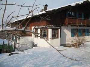 ein Haus mit Schnee auf dem Boden davor in der Unterkunft Haus Regina in Pfronten