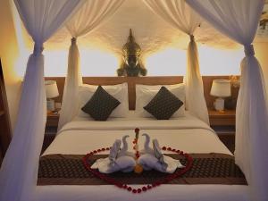 ein Schlafzimmer mit einem Bett mit zwei Schwänen darauf in der Unterkunft The Satya Villa in Ubud