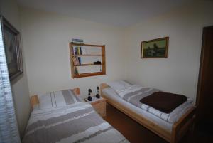 1 Schlafzimmer mit 2 Betten und einem Wandspiegel in der Unterkunft Ferienhaus Hermann, 35522 in Uplengen