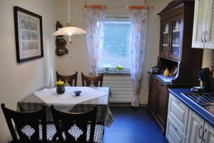 a kitchen with a table and a table and a window at Ferienhaus Hermann, 35522 in Uplengen