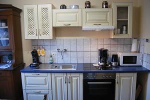 a kitchen with white cabinets and a sink at Ferienhaus Hermann, 35522 in Uplengen