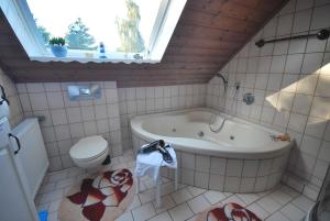 a bathroom with a tub and a toilet and a sink at Ferienwohnung Am Moor, 35629 in Uplengen +29 photos