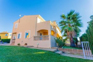 a house with a palm tree in front of it at YupiHome Villa Roser in Alcudia