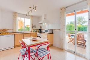 a kitchen with a table and chairs and a dining room at YupiHome Villa Roser in Alcudia