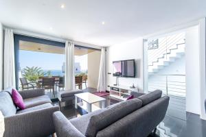 a living room with two couches and a television at YupiHome Villa Aqua in Alcudia
