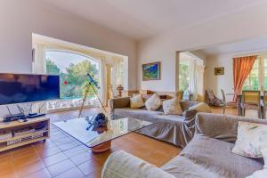 a living room with couches and a flat screen tv at YupiHome Villa Romana Bonaire in Alcudia