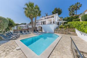 a swimming pool in front of a house at YupiHome Villa Alcanada - Family only in Port d'Alcudia