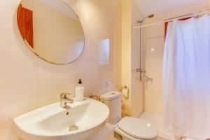 une salle de bains avec lavabo, toilettes et miroir dans l'établissement Villa de les Aguiles, à Alcúdia 24 autres photos