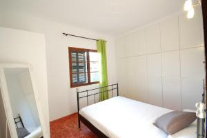 a bedroom with a bed and a window at YupiHome Holiday Home Kety in Portals Nous