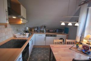 een keuken met witte kasten en een houten aanrecht bij Ferienwohnung Am Moor, 35629 in Uplengen