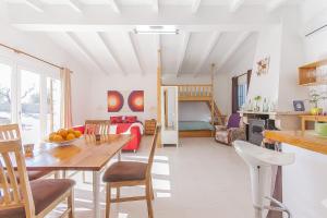 uma cozinha e sala de estar com uma mesa e uma sala de jantar em YupiHome Caseta de Vernissa em Santa Margalida