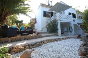a house with a rock garden in front of it at YupiHome Holiday Home Kety in Portals Nous