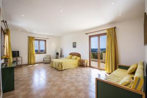 um quarto com uma cama e uma sala de estar com cortinas amarelas em YupiHome Finca Son Morei em Vilafranca de Bonany