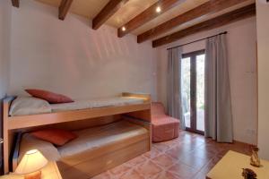 Zimmer mit 2 Etagenbetten und einem Tisch in der Unterkunft YupiHome Finca S'Erissal de Costitx in Costitx
