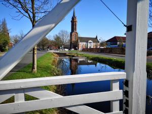 a white fence with a reflection of a church at Ferienwohnung Rossbach, 95061 in Rhauderfehn +21 photos