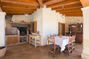 a kitchen with a table and a fireplace at YupiHome Finca Es Bosquet in Inca