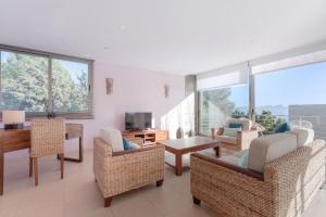 a living room with chairs and a table and windows at YupiHome Villa Alcanada Lighthouse in Alcanada