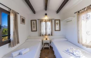 インカにあるYupiHome Finca Tramuntanaの白い壁と窓が備わる客室で、ベッド2台が備わります。