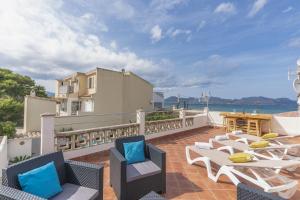 a balcony with chairs and tables and a view of the ocean at CAsA SA MARINA in Alcudia