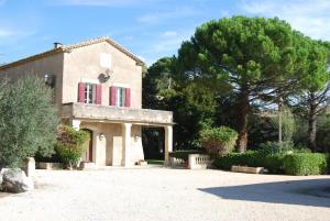 a house with a red window and a tree at Domaine du Grand Malherbes in Aimargues