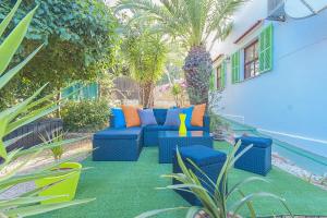 un patio con un divano blu e alcune piante di YupiHome Villa Sophie a Portals Nous