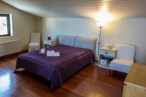 a bedroom with a purple bed and two chairs at Theo Pool Villa Magnificent Sea View in Kapandrítion +31 photos