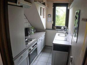 a small kitchen with a sink and a stove at Ferienwohnung Am Traumgarten, 35646 in Uplengen
