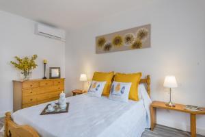 サンタ・マルガリーダにあるYupiHome Holiday Home Ca Ses Terrolesのベッドルーム1室(大型ベッド1台、黄色い枕付)