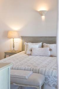a bedroom with a large bed with white sheets and pillows at Saint Andrea Seaside Resort - Adults Only in Naousa