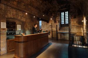 a man standing at a bar in a wine cellar at Hotel La Badia di Orvieto in Orvieto