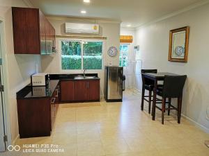 a kitchen with a sink and a table with chairs at Vacation Garden Villa in Thalang