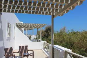 a deck with chairs and a wooden pergola at Saint Andrea Seaside Resort - Adults Only in Naousa