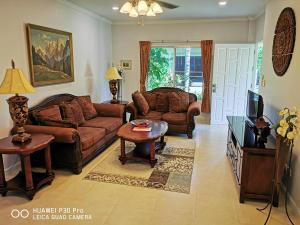 a living room with a couch and a table and a tv at Vacation Garden Villa in Thalang