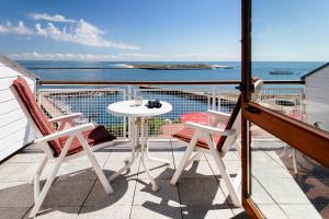 einen Balkon mit einem Tisch, Stühlen und Meerblick in der Unterkunft Haus Rooad Weeter in Helgoland