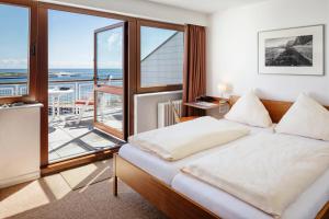 a bedroom with a bed and a balcony at Haus Rooad Weeter in Helgoland