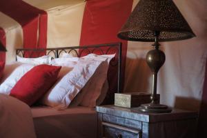 a bedroom with a bed and a lamp on a table at Sahara Bedouin camp in Mhamid