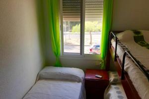 a room with two beds and a window with green curtains at MEDDAYS CHALET EL SOL in Miami Platja +16 photos