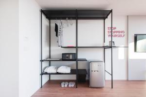 a black bunk bed with two shelves and a refrigerator at HOODY ACTIVE & HAPPINESS HOTEL in Arco +93 photos