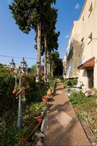 a walkway with potted plants next to a building at Yagen boutique apartments in Haifa