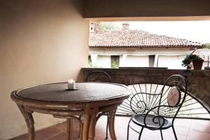 einen Holztisch und Stühle auf einer Terrasse mit einem Tisch und Stühlen in der Unterkunft Cà Borgo Vecchio in Brusasco
