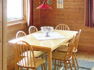 a wooden table with chairs and a glass bowl on it at Three-Bedroom Holiday home in Nordfjordeid 2 in Heggjafrislia
