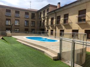 einem Pool vor einem Gebäude in der Unterkunft Apartamentos Turísticos Puente Romano P2 2-A in Salamanca