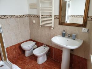 a bathroom with a sink and a toilet and a mirror at I Cavalieri di Malta in Palermo