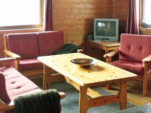 a living room with a table and chairs and a tv at Three-Bedroom Holiday home in Nordfjordeid 2 in Heggjafrislia