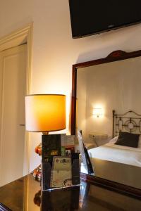 a bedroom with a bed and a lamp and a mirror at Hotel La Badia di Orvieto in Orvieto