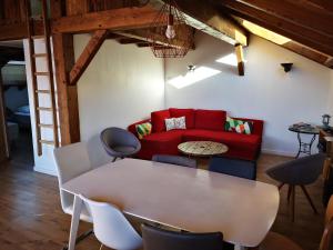 a living room with a red couch and a table at Petit Chalet Vieux Bois in Bozel