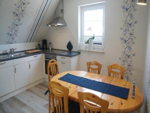 a kitchen with a wooden table and chairs in a kitchen at Ferienwohnung an der Au in Taarstedt