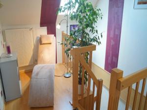 a living room with a staircase and a plant at Ferienwohnung an der Au in Taarstedt
